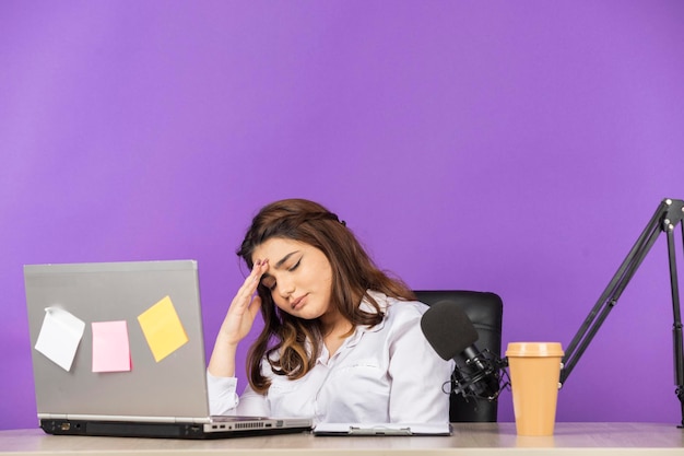 Free photo young businesswoman sitting at the desk and feeling tired high quality photo