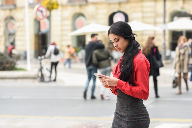 Young businesswoman texting on the street