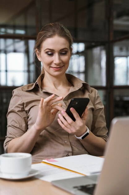 Young businesswoman using her smartphone during a meeting