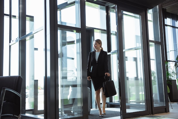 Young businesswoman waiting for departure in airport, work trip, business lifestyle.