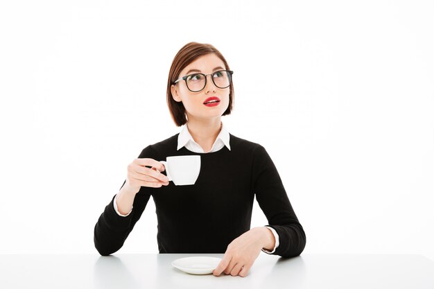 young businesswoman with coffee cup and looking up