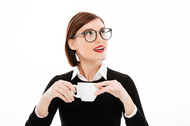 Young businesswoman with coffee or tea cup and laptop computer
