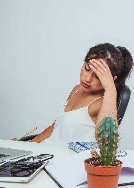 Young businesswoman with headache at work