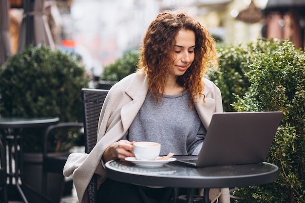 Young businesswoman working on a computer outside the cafe