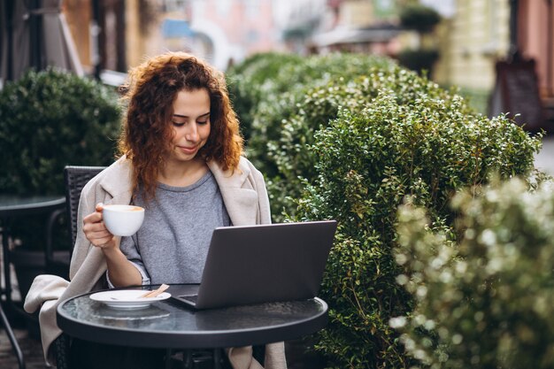 Young businesswoman working on a computer outside the cafe