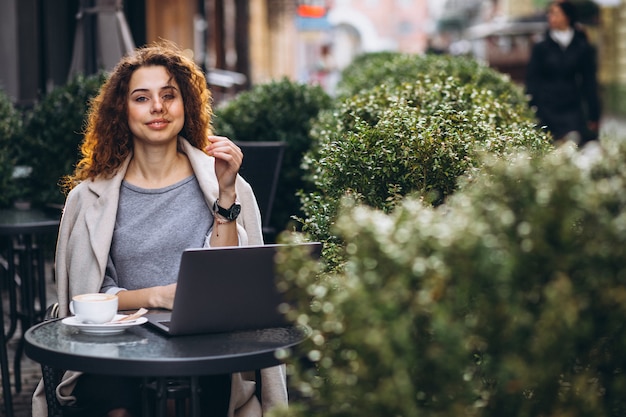 Young businesswoman working on a computer outside the cafe