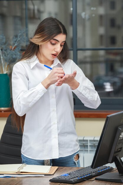 A young businesswoman writing notes to her hand