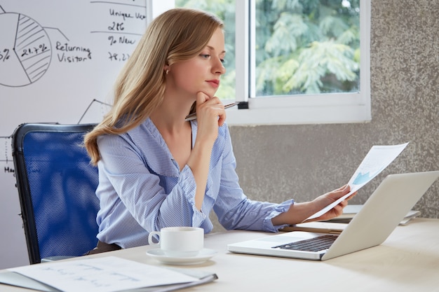 Young career girl in the office thinking over the analysis chart