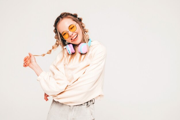 Young carefree model listening to music in wireless headphones