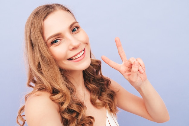 Young carefree woman posing near purple wall in studio