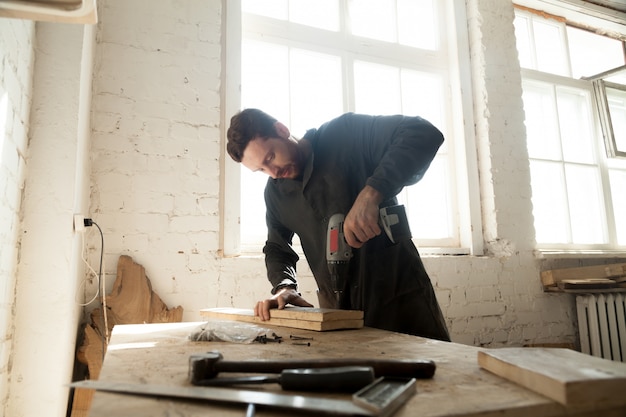 Free photo young carpenter doing woodwork in carpentry