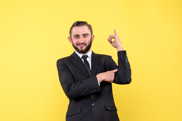 Young casual man pointing finger up with self-satisfied facial expression