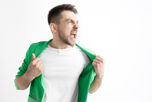 Young casual man shouting. Shout. Crying emotional man screaming on studio background. male half-length portrait. Human emotions, facial expression concept.