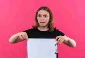 Foto gratuita giovane donna casuale che tiene appunti e sulla parete rosa isolata