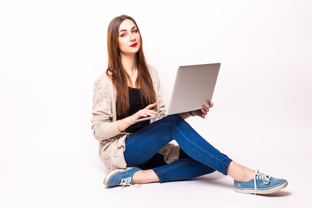 Young casual woman sitting down smiling holding laptop