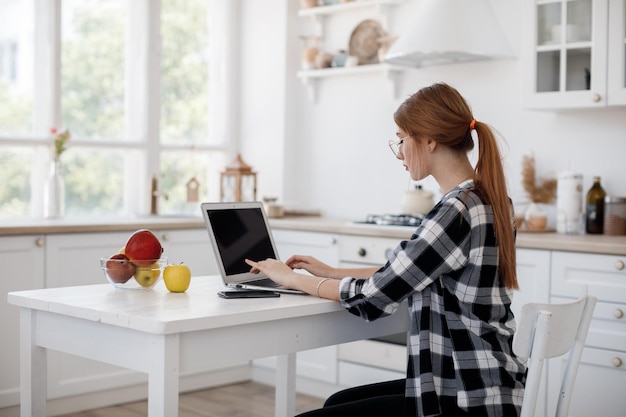 Free photo young casual woman working at home on laptop