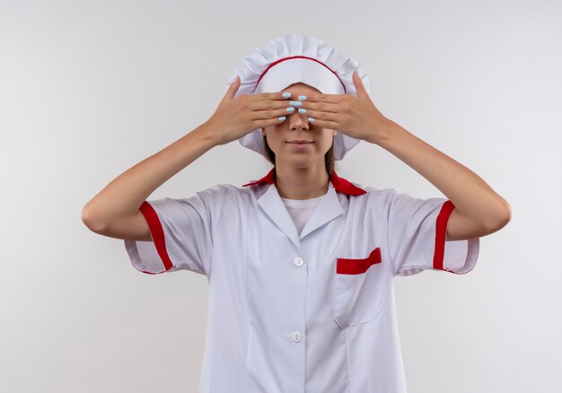 요리사 유니폼에 젊은 백인 요리사 소녀 복사 공간 흰색에 손으로 눈을 닫습니다