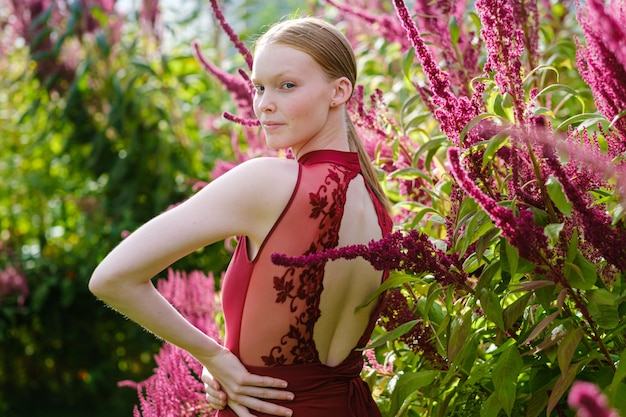 Young Caucasian female ballet dancer posing in burgundy costume