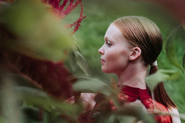 Young caucasian female ballet dancer posing in burgundy costume