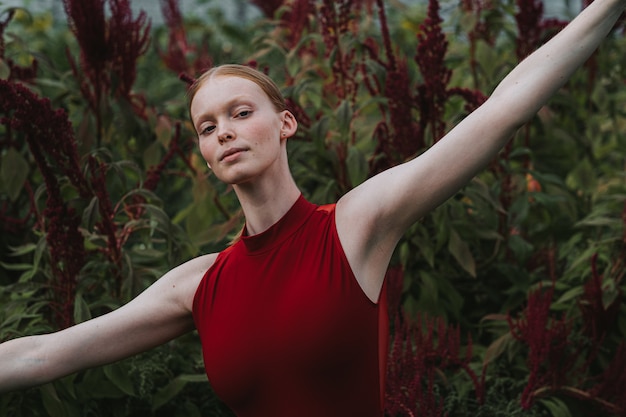 Young Caucasian female ballet dancer posing in burgundy costume