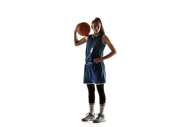 Young caucasian female basketball player of team posing confident with ball isolated on white background.