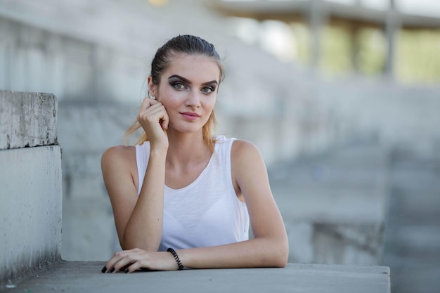 Free photo young caucasian female wearing a sleeveless shirt and posing in a park in bosnia and herzegovina