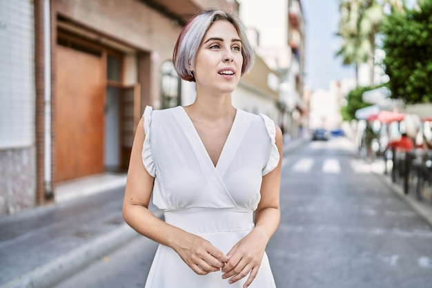 Free photo young caucasian girl smiling happy standing at the city