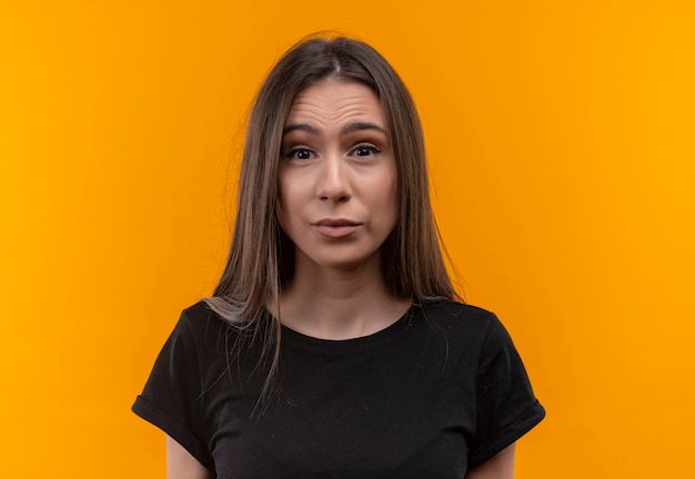 Free photo young caucasian girl wearing black t-shirt on isolated orange wall