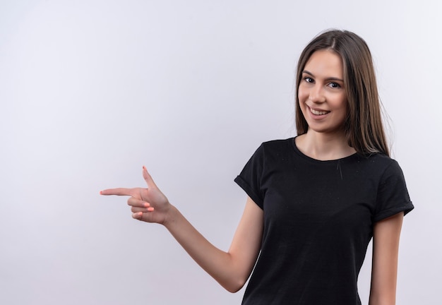 Free photo young caucasian girl wearing black t-shirt points to side on isolated white wall