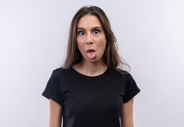 young caucasian girl wearing black t-shirt showing tongue on isolated white wall