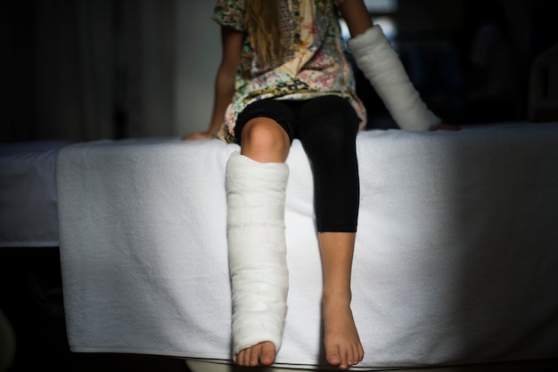 Young Caucasian girl with broken leg in plaster cast