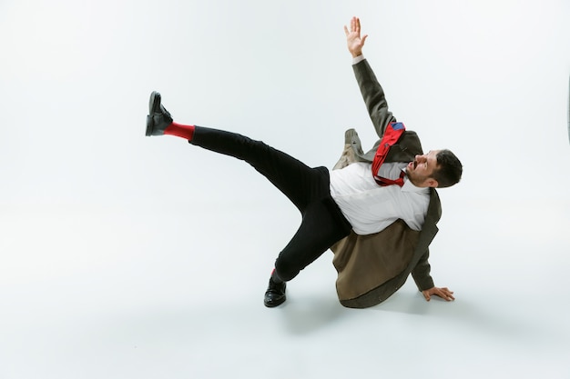 Young caucasian man moving flexible on white