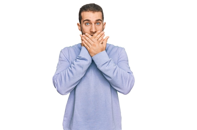 Young caucasian man wearing casual clothes shocked covering mouth with hands for mistake. secret concept.