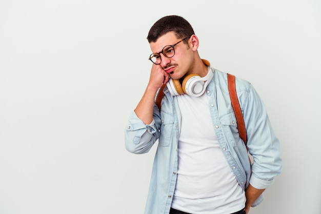 Young caucasian student man listening to music isolated on white wall who feels sad and pensive, looking at copy space.