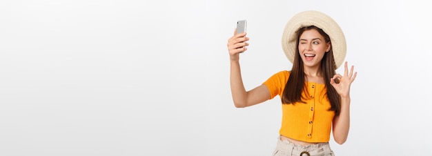 Young caucasian woman enjoying the selfie with herself isolated on white background summer travel co