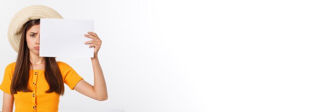 Young caucasian woman holding blank paper sheet over isolated background scared in shock with a surp