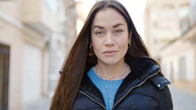 Free photo young caucasian woman standing with serious expression at street