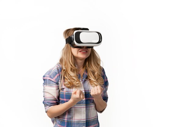 Young caucasian woman using VR-headset devices, gadgets isolated on white studio wall.