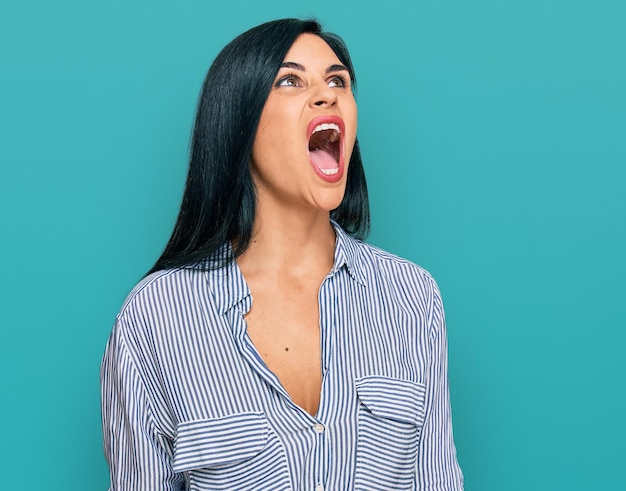 Free photo young caucasian woman wearing casual clothes angry and mad screaming frustrated and furious, shouting with anger. rage and aggressive concept.