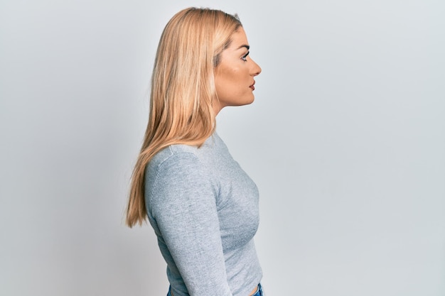 Young caucasian woman wearing casual clothes looking to side, relax profile pose with natural face with confident smile.