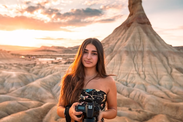 Молодая кавказская женщина с камерой перед формированием кастильдетьерра в пустыне барденас-реалес, наварра, страна басков.