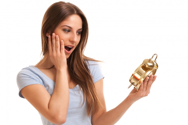 Young caucasian woman with alarm clock 