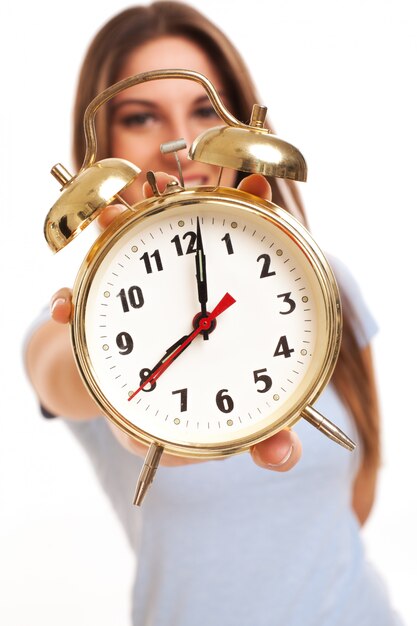 Young caucasian woman with alarm clock 