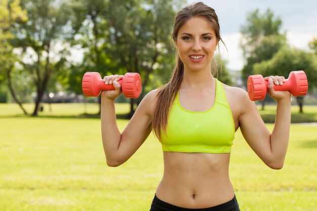 Young caucasian woman with dumbbells