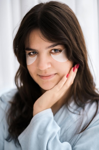 Free photo a young caucasian woman with patches under her eyes looking into the camera