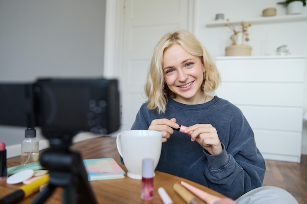 Free photo young charismatic beauty blogger teenage girl records video of her applying mascara reviewing makeup