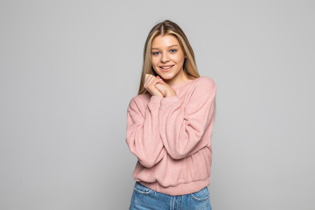 Young charming happy woman standing isolated on gray wall