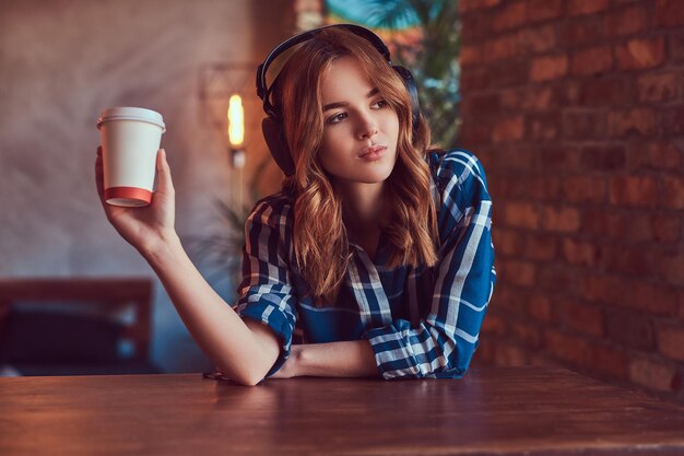 A young charming sensual girl listening to a music in headphones