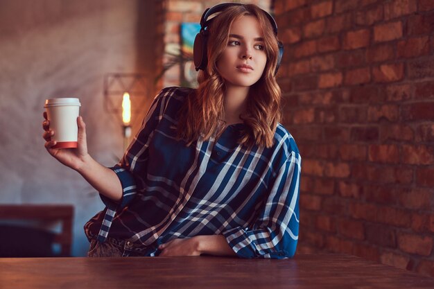 A young charming sensual girl listening to a music in headphones
