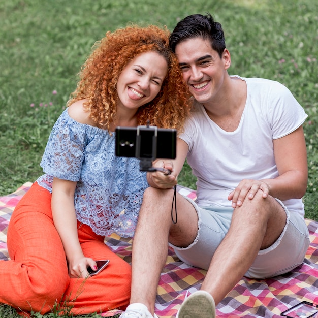 Young and cheerful couple taking selfies